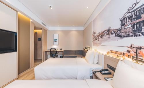 a hotel room with two beds and a tv at Atour Hotel Shanghai New International Expo Center Maglev Station in Shanghai