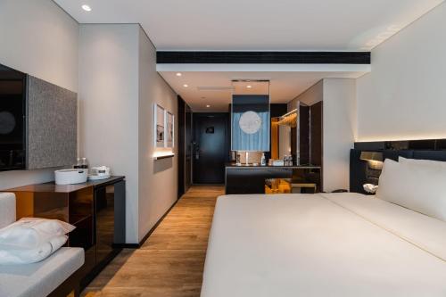 a bedroom with a large bed and a living room at Atour S Hotel Shanghai Lujiazui Financial Center in Shanghai