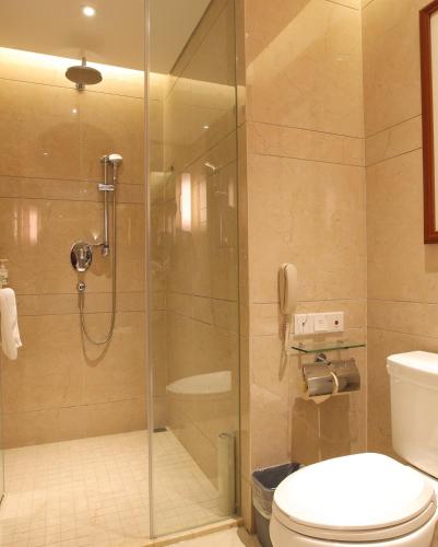 a bathroom with a shower and a toilet and a phone at Atour Hotel Wangfujing Ave Xinjiekou Nanjing in Nanjing