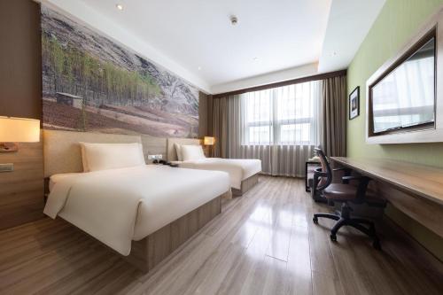 a hotel room with two beds and a desk at Atour Hotel Jinan High-tech Wanda Plaza Tiancheng Road in Jinan