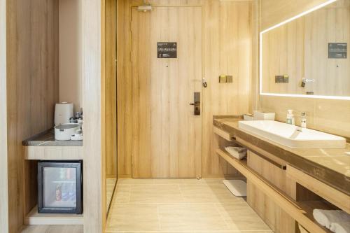 a bathroom with a sink and a mirror at Atour Hotel Harbin Convention and Exhibition Center Nongken in Harbin