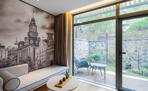 a living room with a large window with a clock tower at Atour S Hotel Lujiazui Oriental Pearl Shanghai in Shanghai