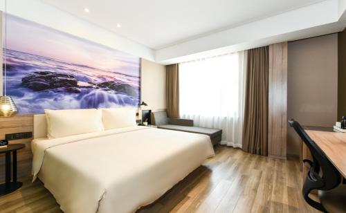 a hotel room with a bed and a large window at Atour Hotel Dalian Development Zone Jinma Road in Dalian