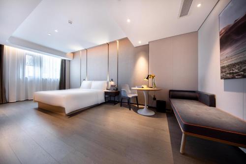1 dormitorio con cama, mesa y sofá en Atour Hotel Shenzhen Qianhai Baoan Center, en Bao'an