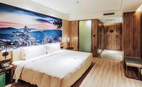a bedroom with a large bed and a painting on the wall at Atour Hotel North High Speed Railway Station Xi'an in Xi'an