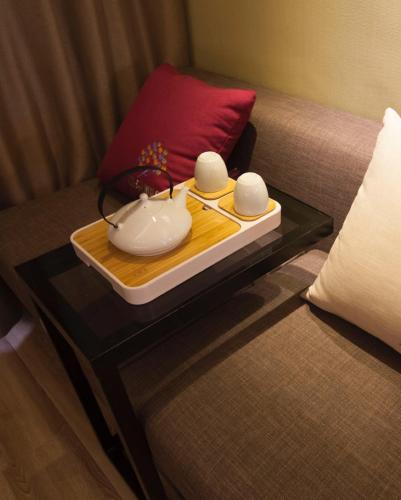 a tray with bowls and chopsticks on a table on a couch at Atour Hotel Jinan High-tech Wanda Plaza Tiancheng Road in Jinan