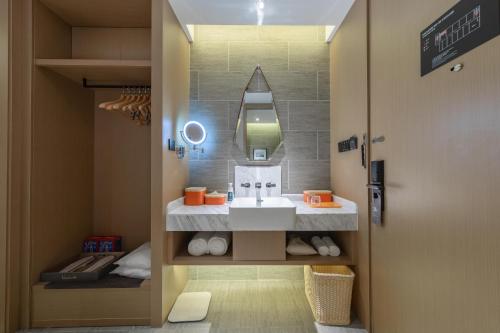 a bathroom with a sink and a mirror at Atour Hotel Chongqing Jiangbei International Airport Huixing Light Rail Station in Chongqing