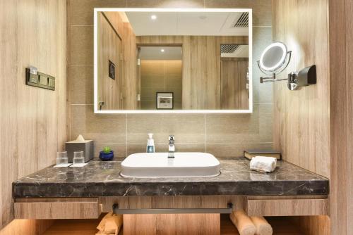 a bathroom with a sink and a mirror at Atour Hotel Capital Airport Beijing in Beijing