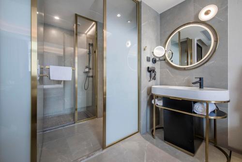 a bathroom with a sink and a mirror at Atour Hotel Zhuhai Gongbei Port Fuhuali CBD in Zhuhai