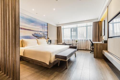 深セン市にあるAtour Hotel Shenzhen Nanshan Science and Technology Park Keyuan Roadのベッドとデスクが備わるホテルルームです。