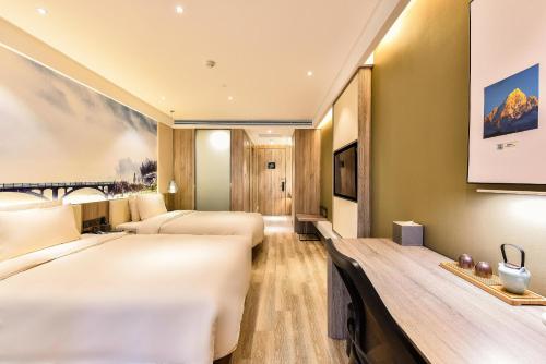 a hotel room with two beds and a tv at Atour Hotel Capital Airport Beijing in Beijing