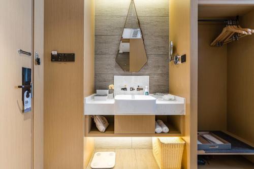 a bathroom with a white sink and a mirror at Atour Hotel Wushan Road Fuzhou Three Lanes and Seven Alleys in Fuzhou