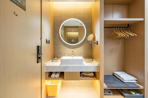 ein Bad mit einem Waschbecken und einem Spiegel in der Unterkunft Atour Hotel Hefei Binhu International Convention and Exhibition Center in Hefei