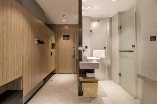 uma casa de banho com um lavatório e um espelho em Atour Hotel Suzhou Railway Station North Square Bole Shi em Suzhou