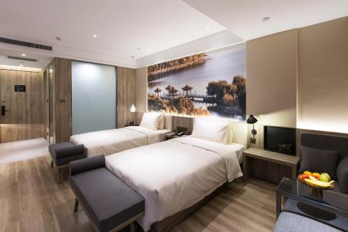 a hotel room with two beds and a couch at Atour Hotel International Convention and Exhibition Center Changchun in Changchun