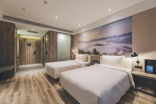 a hotel room with two beds and a tv at Atour Hotel Chongqiang Jiangbei Airport in Chongqing