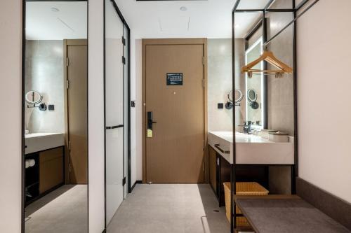 een badkamer met een wastafel en een spiegel bij Atour Hotel Xiamen Zhongshan Road General Temple in Xiamen