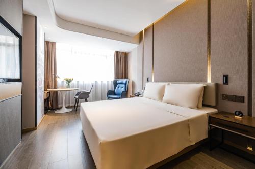 a hotel room with a large bed and a table at Atour Hotel Wushan Road Fuzhou Three Lanes and Seven Alleys in Fuzhou