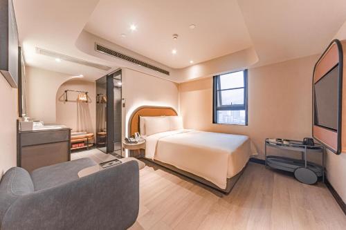 una camera d'albergo con letto e divano di Atour Light Hotel Chunxi Road Subway Station Taikoo Li Chengdu a Chengdu