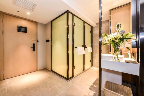 a bathroom with a shower and a sink and a mirror at Atour Hotel South Luogu Lane Beijing in Beijing