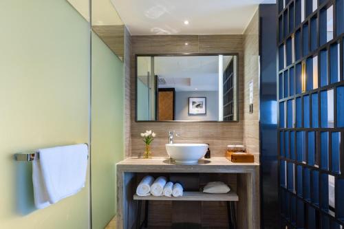 La salle de bains est pourvue d'un lavabo et d'un miroir. dans l'établissement Atour X Hotel Shenzhen Luohu Dongmen Pedestrian Street, à Shenzhen