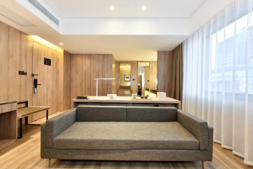 a living room with a couch and a table at Atour Hotel Dalian Development Zone Jinma Road in Dalian