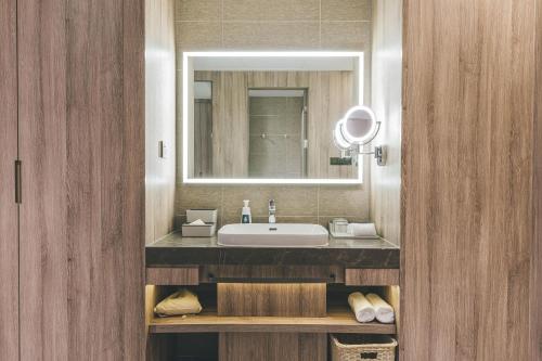 ein Bad mit einem Waschbecken und einem Spiegel in der Unterkunft Atour Hotel Chongqiang Jiangbei Airport in Chongqing