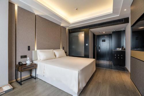 sypialnia z dużym białym łóżkiem i stołem w obiekcie Atour Hotel Wushan Road Fuzhou Three Lanes and Seven Alleys w mieście Fuzhou