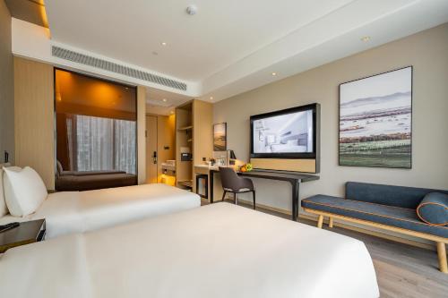 a hotel room with two beds and a desk at Atour Hotel Hefei Binhu International Convention and Exhibition Center in Hefei