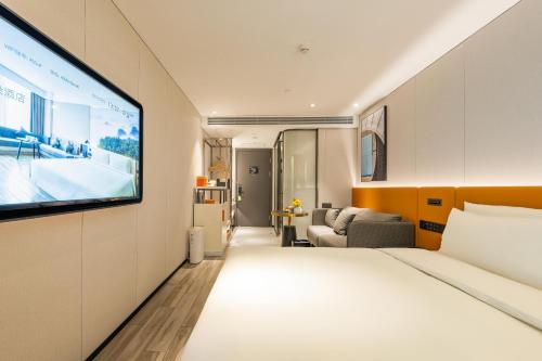 a hotel room with a bed and a flat screen tv at Atour Hotel Beijing Tiananmen Wangfujing Pedestrian in Beijing