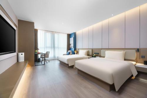 濟南的住宿－济南西站亚朵酒店，酒店客房设有两张床和一台平面电视。