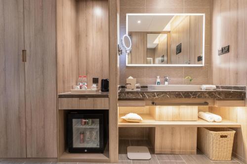 uma casa de banho com um lavatório e um espelho em Atour Hotel Wuhan Tianhe Airport Tenglong Avenue Subway Station em Wuhan