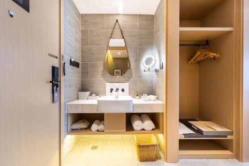 a bathroom with a sink and a mirror at Atour Hotel Shenzhen Baoan International Convention and Exhibition Center in Bao'an