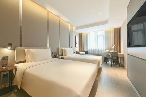 a hotel room with two beds and a television at Atour Hotel Beijing Joy City Chaoyang Road in Beijing