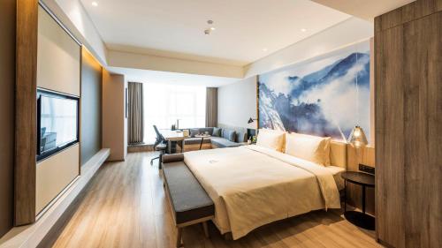a hotel room with a large bed and a television at Atour Hotel North High Speed Railway Station Xi'an in Xi'an