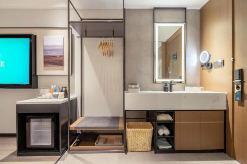 een badkamer met een wastafel en een spiegel bij Atour Hotel Dalian Development Zone in Dalian