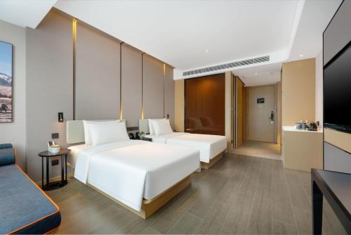 a hotel room with two beds and a television at Atour Hotel Jinan Yaoqiang International Airport in Jinan