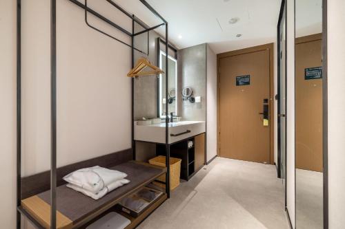 a bathroom with a sink and a mirror at Atour Hotel Xiamen Zhongshan Road General Temple in Xiamen