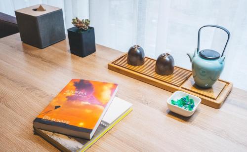 a table with a book and other items on it at Atour Hotel Hongqiao Hub National Exhibition Center Shanghai in Shanghai