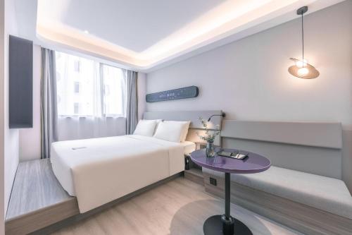 um quarto de hotel com uma cama e uma mesa em Atour Light Hotel Shanghai East Nanjing Road em Xangai