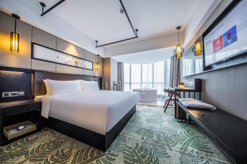 深セン市にあるAtour X Hotel Shenzhen Luohu Dongmen Pedestrian Streetのベッドとテレビが備わるホテルルームです。