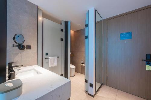 a bathroom with a tub and a sink and a toilet at Atour Hotel Shenzhen Baoan Vanke Star City in Bao'an