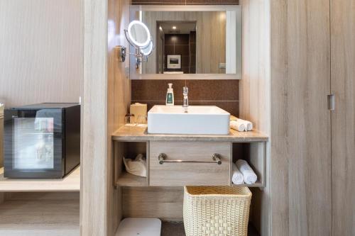 a bathroom with a sink and a microwave at Atour Hotel Jinan High-tech Wanda Plaza Tiancheng Road in Jinan