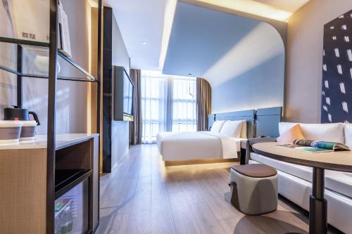 um quarto de hotel com uma cama e uma mesa em Atour S Hotel Tianjin Binjiang Road Hanglung Plaza em Tianjin