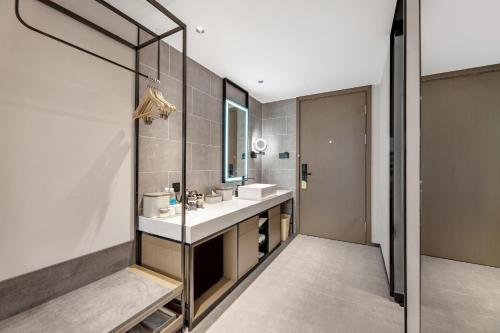 La salle de bains est pourvue d'un lavabo et d'un miroir. dans l'établissement Atour Hotel Changsha Pedestrian Street IFC Center, à Changsha