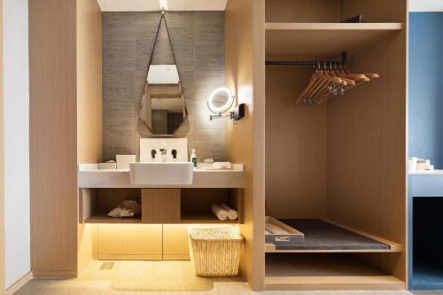 a bathroom with a sink and a mirror at Atour Hotel South Jinan Industrial Road CBD in Jinan