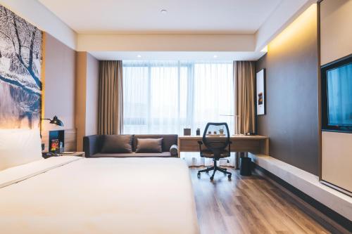 a hotel room with a bed and a desk at Atour Hotel Hongqiao Hub National Exhibition Center Shanghai in Shanghai