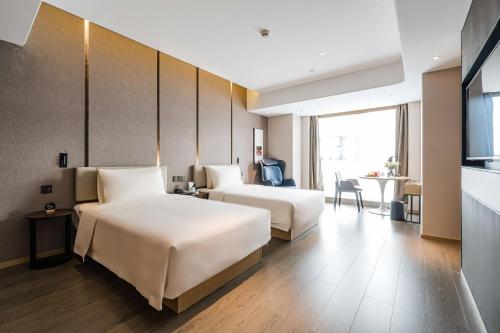 a hotel room with two beds and a table at Atour Hotel Chengdu Taikoo Li Future Center in Chengdu