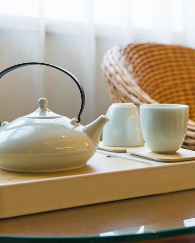 a tea pot and two cups on a table at Atour Hotel Wangfujing Ave Xinjiekou Nanjing in Nanjing
