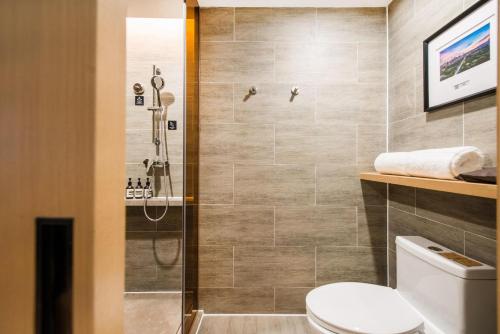 a bathroom with a shower and a toilet at Atour Hotel Shenzhen Baoan International Airport in Bao'an